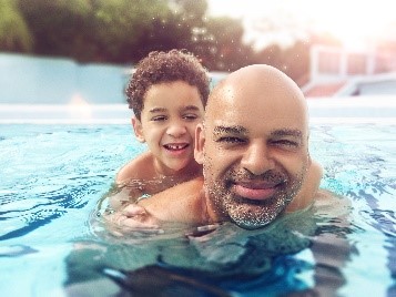 Photo of a father and son swimming in a pool.